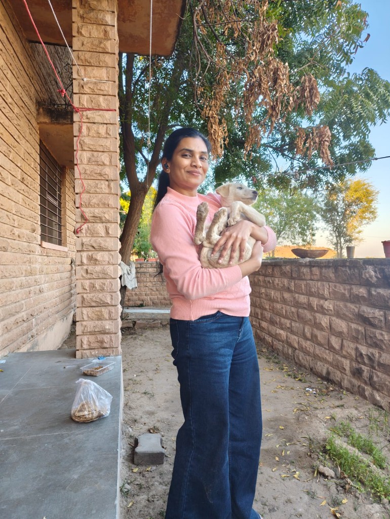Vandana Kaparia smiling while holding a rescued puppy